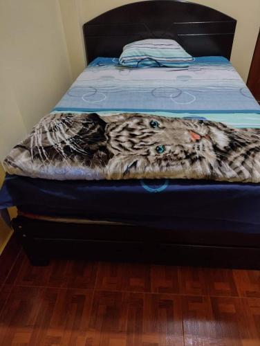 ein Bett mit blauer Matratze und einer Decke darauf in der Unterkunft HOSPEDAJE NELLY in Malabrigo