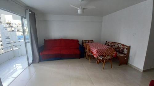 Habitación con mesa, cama, mesa y sillas. en Ap Papyrus - Balneário Camboriú-SC, en Balneário Camboriú