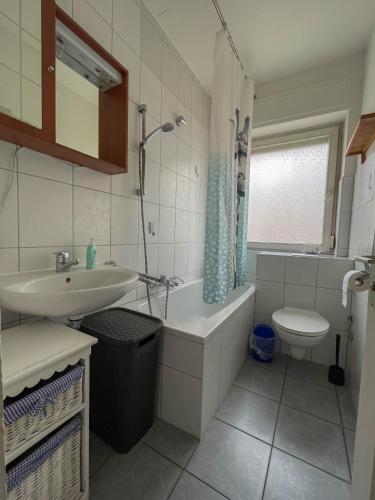 a bathroom with a sink and a tub and a toilet at Apartments Sülmerstrasse in Heilbronn