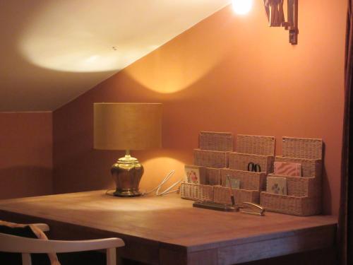 a table with a lamp and some boxes on it at Zintuinen in Esbeek
