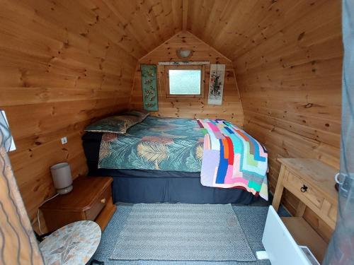 a bedroom in a log cabin with a bed in it at Rum Bridge 'Hazels' Pet Friendly Glamping Pod in Clare