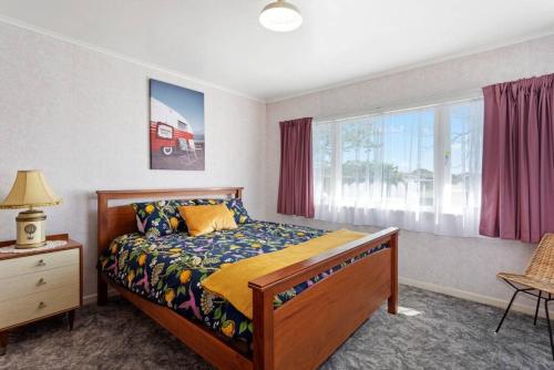 a bedroom with a bed and a window at Retro Cottage in Opotiki CBD in Opotiki