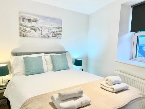 a bedroom with a large white bed with towels on it at *Modern & Stylish 2 Double Bedroom-Free Parking!* in Bristol