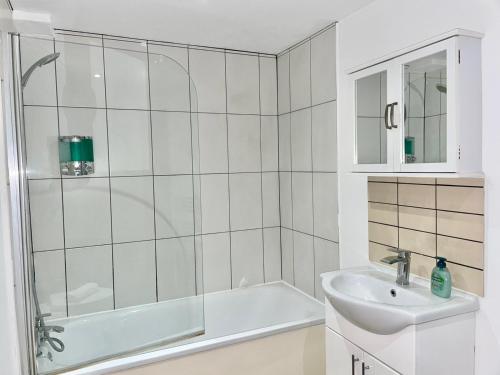 y baño blanco con lavabo y ducha. en *Modern & Stylish 2 Double Bedroom-Free Parking!*, en Bristol