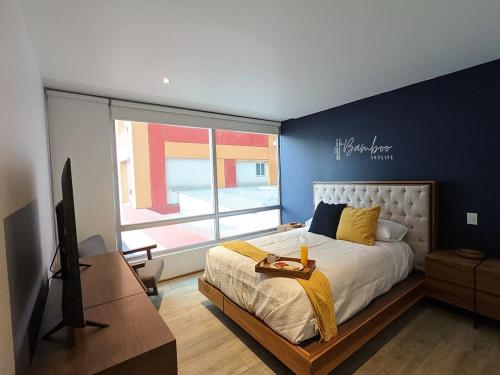 1 dormitorio con 1 cama, TV y ventana en Luxury Condo Santa Fe Cosmocrat By Bamboo Skylife, en Ciudad de México