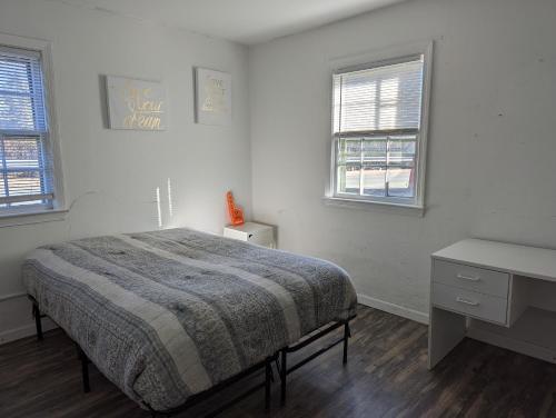 1 dormitorio con 1 cama, escritorio y 2 ventanas en Historic UVA Apartment - near the corner en Charlottesville