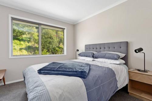 a bedroom with a large bed and a window at Coast View Farm Stay in Opotiki