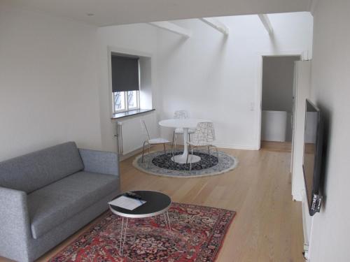 a living room with a couch and a table at Guesthouse Sharon Apartments in Aarhus