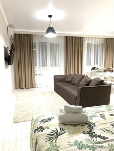 sala de estar con sofá y mesa en # 50 Солнечная комфортная студия, en Atyraū