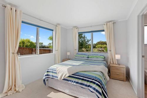 a bedroom with a bed and a large window at Waiotahe Executive Getaway in Opotiki