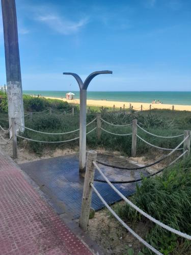 a street light next to a fence and a beach at Apartamento perto da praia de Itaparica in Vila Velha