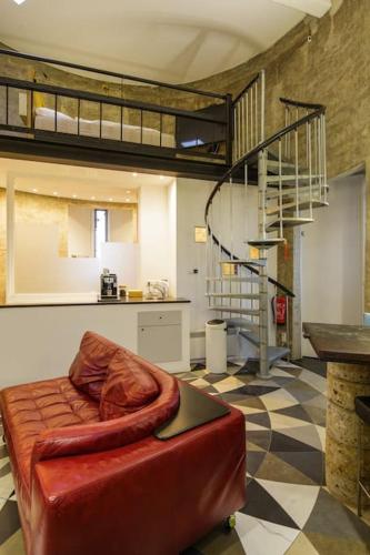 a living room with a red couch and a staircase at Verblijf boven in de watertoren van Strijen met dakterras in Strijen