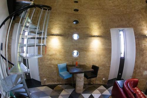 ein Esszimmer mit einem Tisch und einer Wendeltreppe in der Unterkunft Verblijf boven in de watertoren van Strijen met dakterras in Strijen