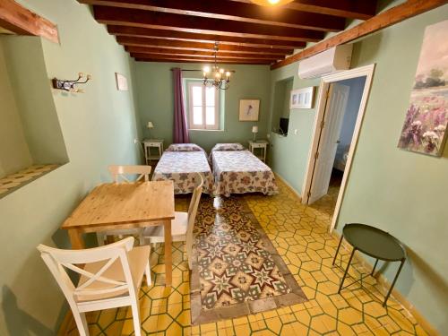 a room with two beds and a table and chairs at Pensión España in Cádiz