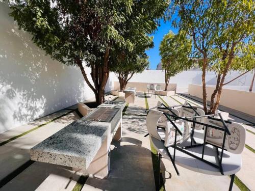 a row of benches sitting on a sidewalk with trees at Casa SOL #222, para 6 personas in La Paz