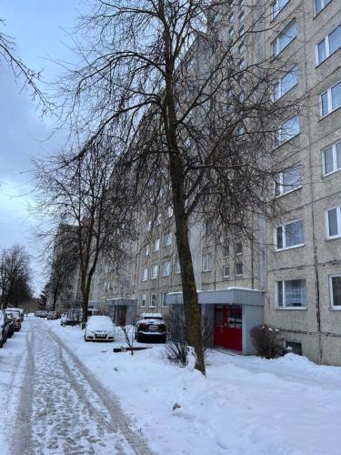 a snow covered street in front of a building at Kärberi Apartments in Tallinn