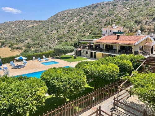 a house with a mountain in the background at Horizon Pissouri Bay 1 bedroom apartment with communal pool in Pissouri