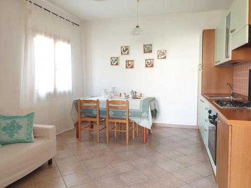 kuchnia ze stołem i krzesłami w pokoju w obiekcie comfortable appartment close to the beach w mieście Isola Rossa