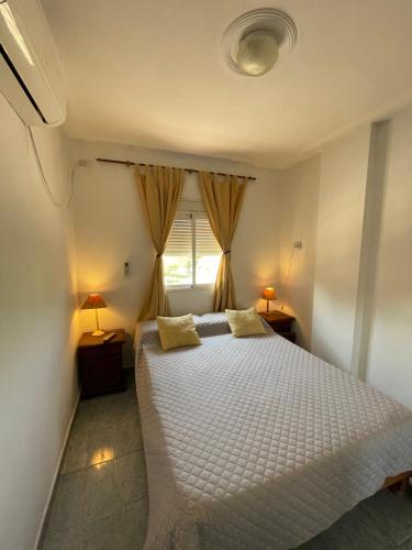 1 dormitorio con cama blanca y ventana en Hotel Salvador Catamarca en San Fernando del Valle de Catamarca