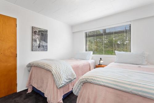 a bedroom with two beds and a window at Kate and Harrys in Opotiki