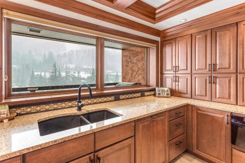 eine Küche mit Holzschränken, einem Waschbecken und einem Fenster in der Unterkunft Lion Square Lodge South 750A in Vail