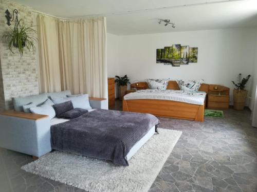 1 dormitorio con 2 camas y sofá en Ferienwohnung, Sauna & Gästekarte gratis im Schwarzwald, en Baiersbronn