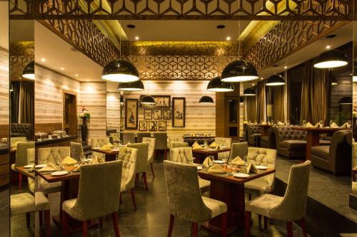 a restaurant with tables and chairs in a room at Vesta Bikaner Palace in Bikaner
