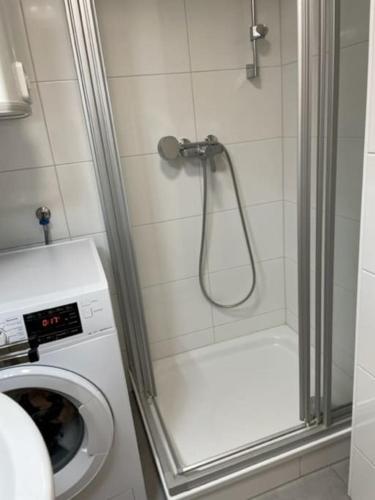 een douche in een badkamer met een wasmachine bij City Appartement 4600 in Wels