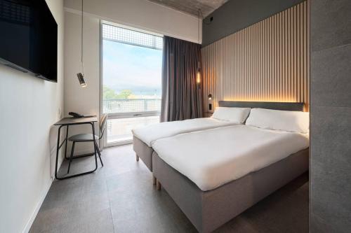 ein Hotelzimmer mit einem großen Bett und einem Fenster in der Unterkunft Zleep Madrid Airport in Madrid