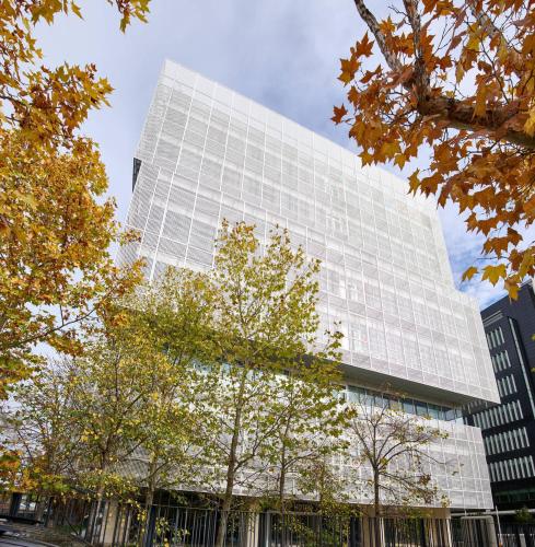a tall white building with trees in front of it at Zleep Madrid Airport in Madrid