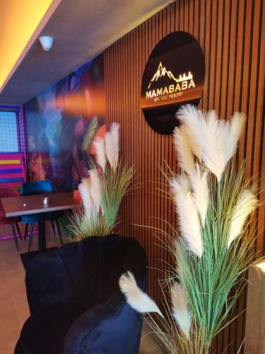 a restaurant with feather plants and a sign on the wall at NLux 11 Apartment in Kopaonik