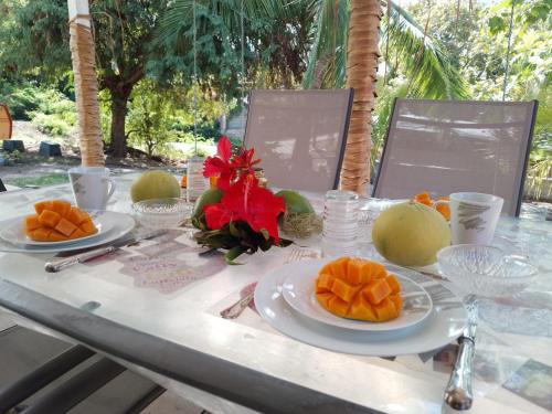 a table with plates of fruit on top of it at Chez Laeti et Mano in Hakamui