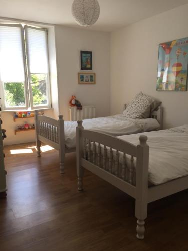 une chambre avec deux lits et un canapé dans l'établissement Le Gite du Petit Renard: A Tranquil Gite with pool, à Oradour-Saint-Genest