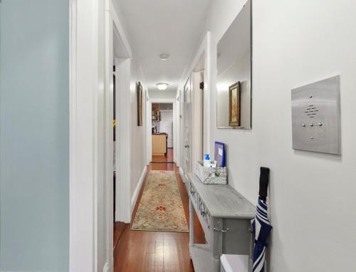 un pasillo con paredes blancas y una mesa en una habitación en Bright & Spacious 2Br apartment, mins from Downtown Boston, parking en Boston