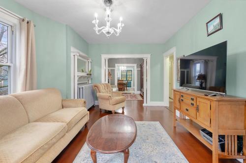 a living room with a couch and a table at Bright & Spacious 3BR, Mins from Downtown, Easy to Gillette, Parking in Boston