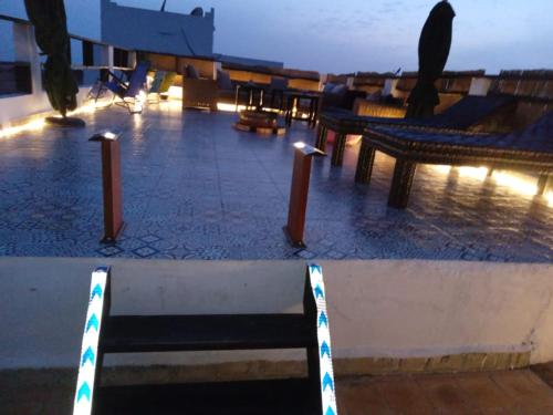 a row of benches sitting on a patio at night at La colina House taghazout in Taghazout