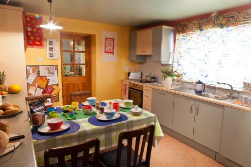 a kitchen with a table with dishes on it at 1 Tan Yr Eglwys Barn Cottage in Pontardawe