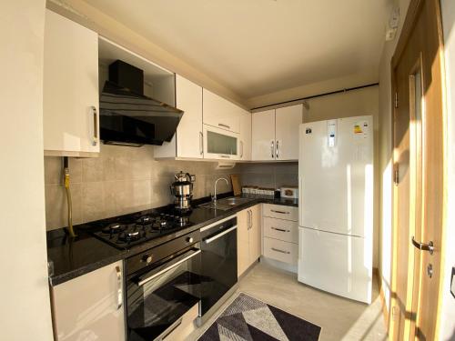 una cucina con armadietti bianchi, piano cottura e frigorifero di Luxury home in Istanbul's Golden Horn a Istanbul