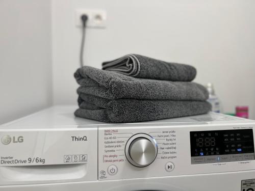 een stapel handdoeken bovenop een wasmachine bij Klingerka brand new 1-bedroom apartment free parking in Nivy