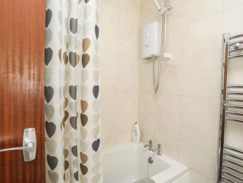 a bathroom with a shower and a tub and a sink at 5 Ger Y Nant in Pwllheli
