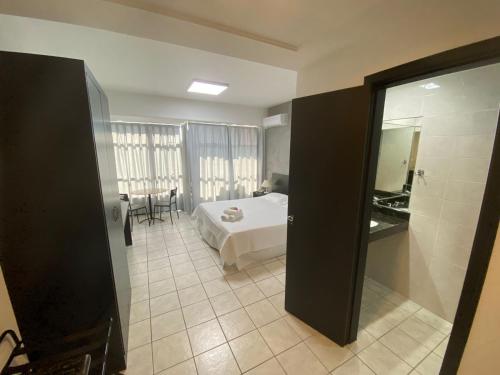 1 dormitorio con cama, mesa y espejo en Savassi Village, en Belo Horizonte