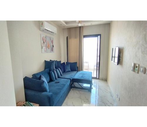 a blue couch in a living room with a window at شاليه للايجار اليومى بورتو سعيد in Port Said