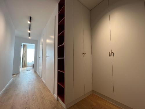 an empty room with white cabinets and a hallway at Klingerka brand new 1-bedroom apartment free parking in Nivy
