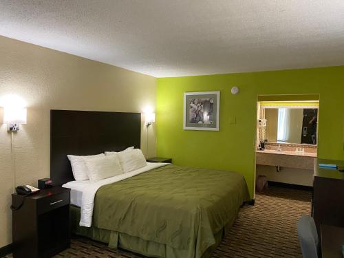 a hotel room with a bed with green walls at Quality Inn Elizabeth City near University in Elizabeth City