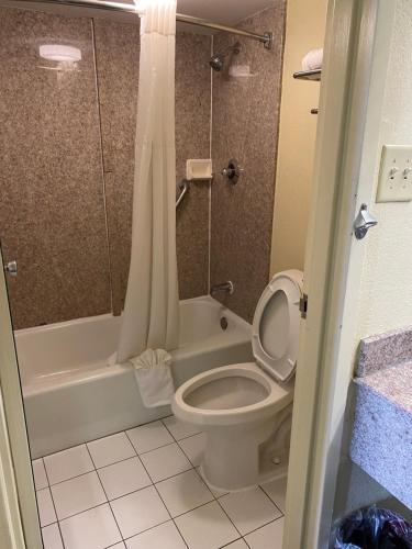 a bathroom with a toilet and a tub and a shower at Quality Inn Elizabeth City near University in Elizabeth City