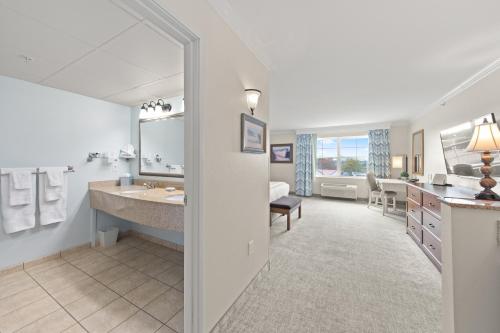 La salle de bains est pourvue d'un grand lavabo et d'un grand miroir. dans l'établissement Hotel Rehoboth, à Rehoboth Beach