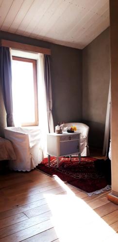 a living room with a table and a window at B&B EcoAntico casa in paglia in Maiolo