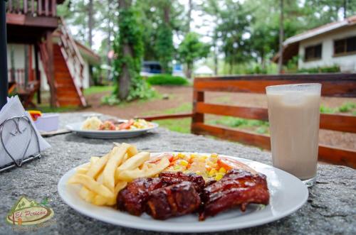 a plate of food and french fries and a glass of milk at Cabañas y Mirador El Pericón in Arambala
