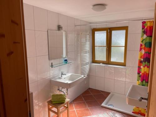 Baño blanco con lavabo y bañera en Annaberg TOP 1, en Annaberg im Lammertal