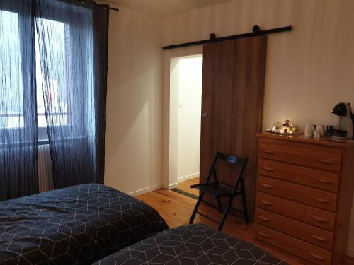 ein Schlafzimmer mit einem Bett, einer Kommode und einem Fenster in der Unterkunft sas Road Runner Café in Égliseneuve-dʼEntraigues